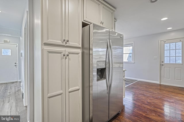 kitchen with dark hardwood / wood-style flooring and stainless steel fridge with ice dispenser