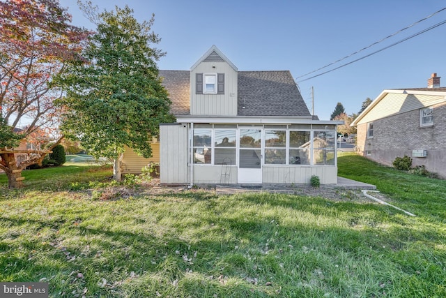 back of house featuring a yard and a sunroom