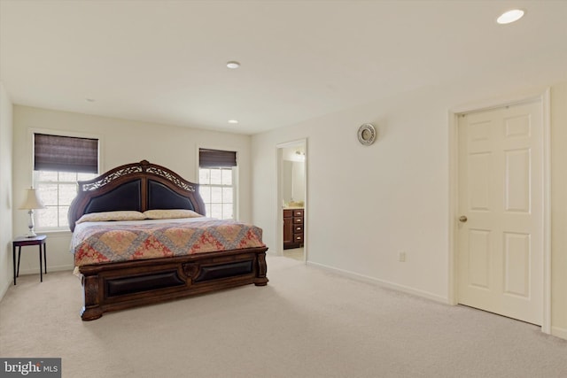 carpeted bedroom featuring multiple windows and connected bathroom