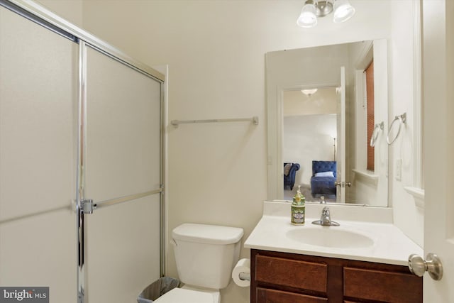 bathroom with vanity, toilet, and a shower with shower door