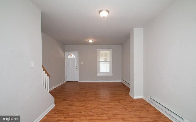 foyer featuring a baseboard heating unit and light wood-type flooring