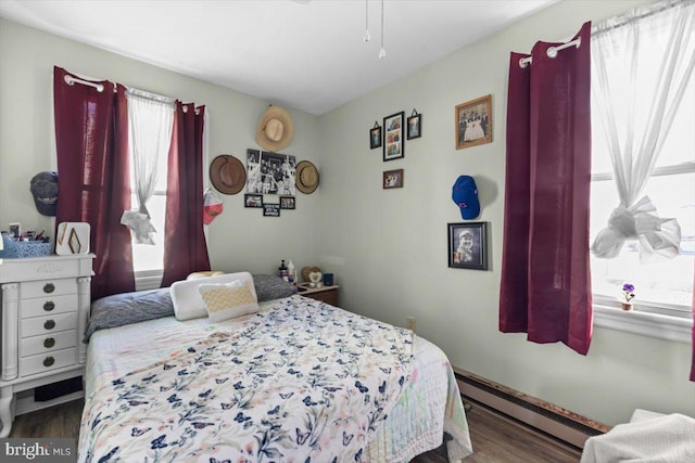 bedroom with baseboard heating and hardwood / wood-style floors