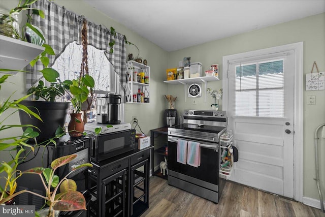 kitchen featuring stainless steel electric stove and dark hardwood / wood-style flooring