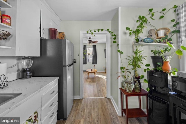 kitchen featuring ceiling fan, stainless steel fridge, dark hardwood / wood-style floors, and white cabinets