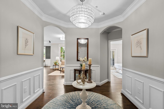 corridor with ornamental molding, dark hardwood / wood-style floors, and a notable chandelier