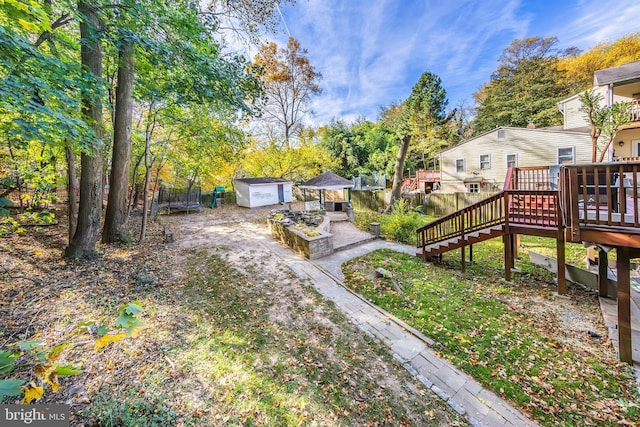 view of yard featuring an outbuilding, a shed, a gazebo, a wooden deck, and stairway