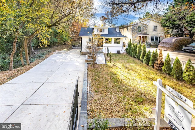 view of front of property with a front yard and a shingled roof