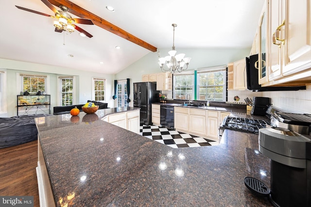 kitchen featuring pendant lighting, black appliances, lofted ceiling with beams, open floor plan, and a sink