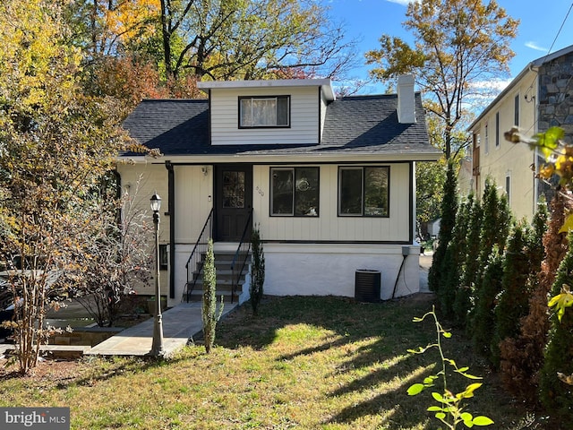 bungalow-style home with entry steps, a chimney, a shingled roof, and a front lawn