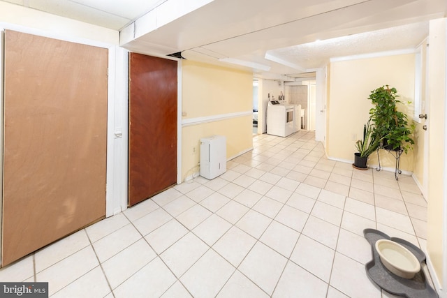 spare room featuring baseboards, washing machine and dryer, and light tile patterned flooring