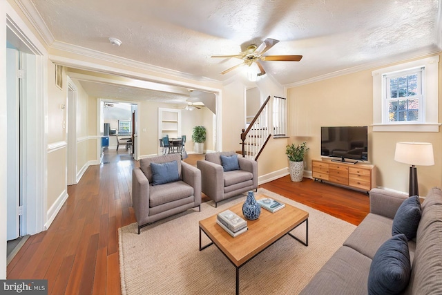 living room with wood finished floors, stairway, and a textured ceiling