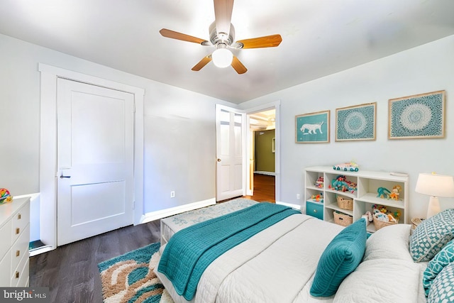 bedroom with baseboards, a ceiling fan, and dark wood-type flooring