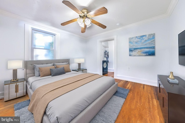 bedroom with baseboards, a ceiling fan, wood finished floors, and ornamental molding