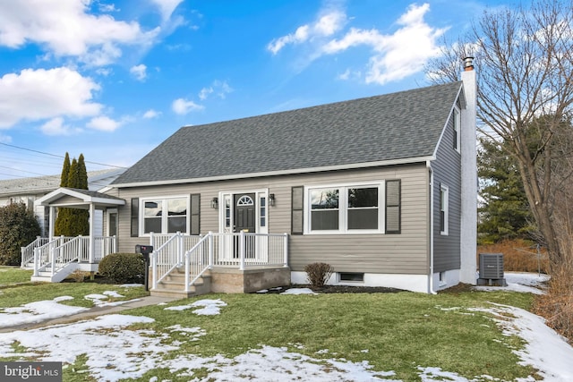 view of front of home with central AC unit and a yard