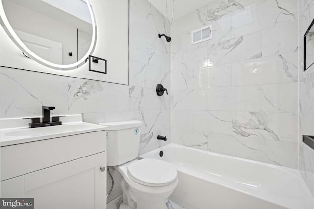 full bathroom with tiled shower / bath, tile walls, backsplash, vanity, and toilet