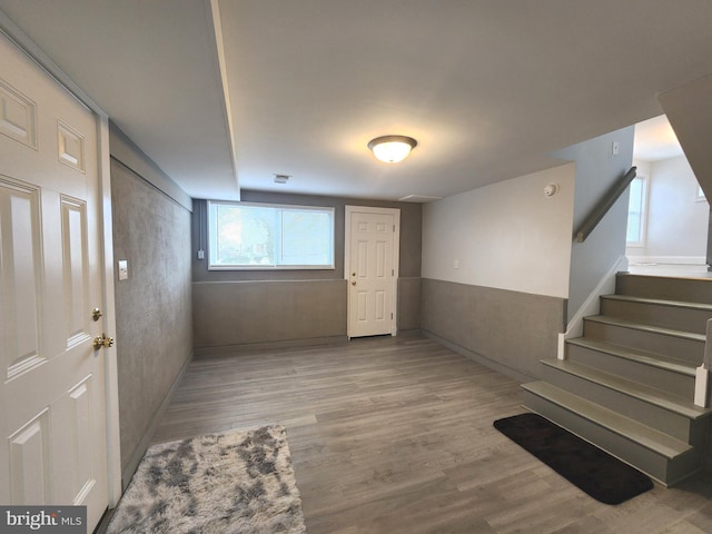 entrance foyer with baseboards, light wood finished floors, and stairs