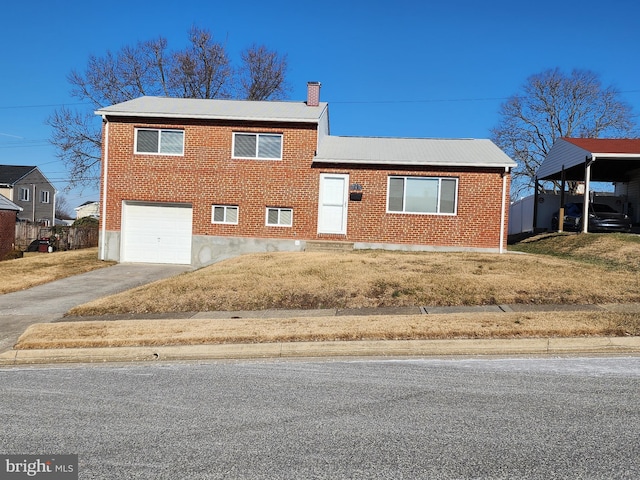 tri-level home with a garage, brick siding, driveway, and a chimney