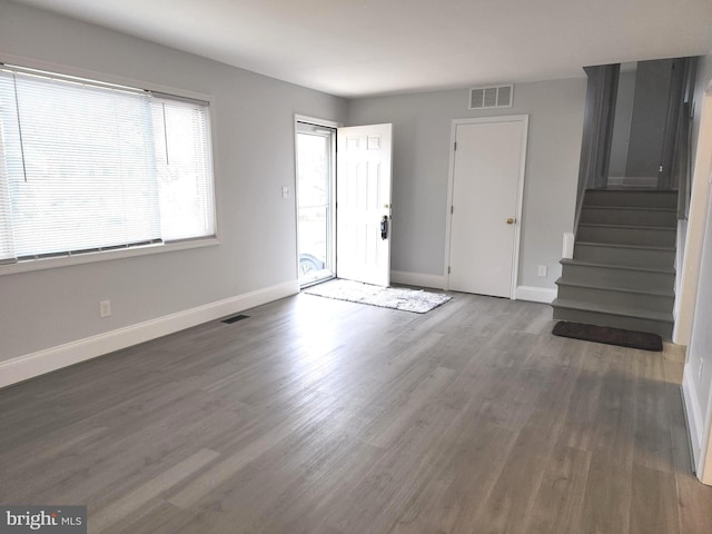 foyer with baseboards, stairs, and visible vents