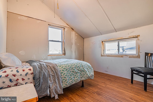 bedroom featuring hardwood / wood-style floors and vaulted ceiling