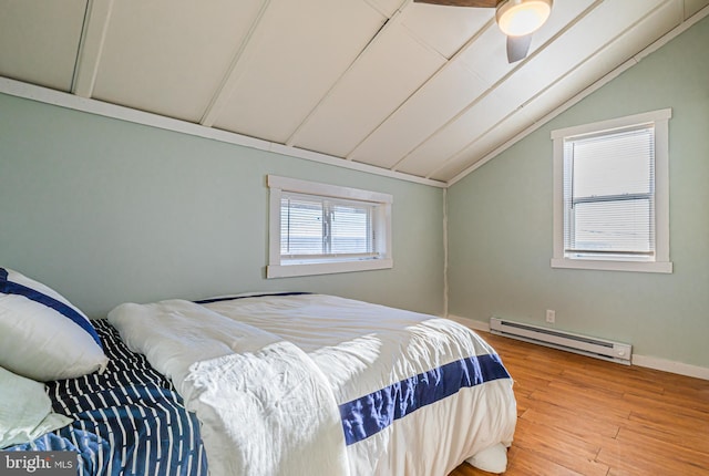 bedroom with hardwood / wood-style flooring, vaulted ceiling, ceiling fan, and baseboard heating