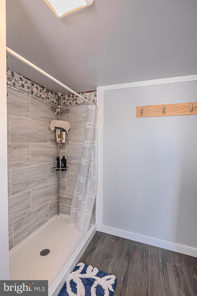 bathroom featuring wood-type flooring and a shower with curtain