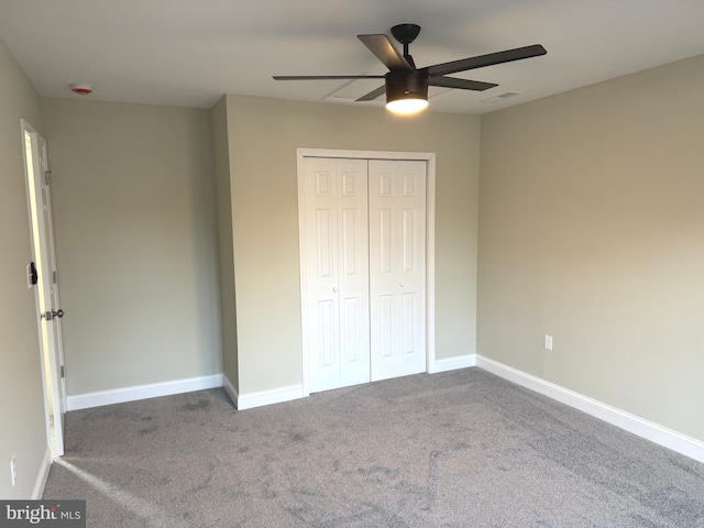 unfurnished bedroom with ceiling fan, carpet flooring, and a closet