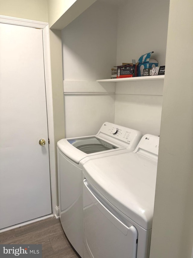 laundry area with dark wood-type flooring and washer and dryer