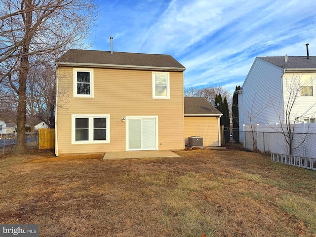 rear view of property featuring a yard, central AC, and a patio area