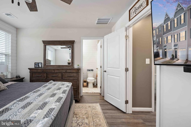 bedroom with dark wood-type flooring, connected bathroom, and ceiling fan