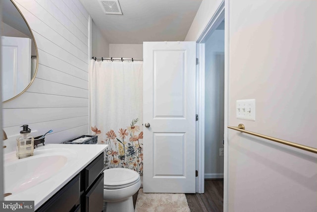 bathroom featuring hardwood / wood-style flooring, toilet, and vanity