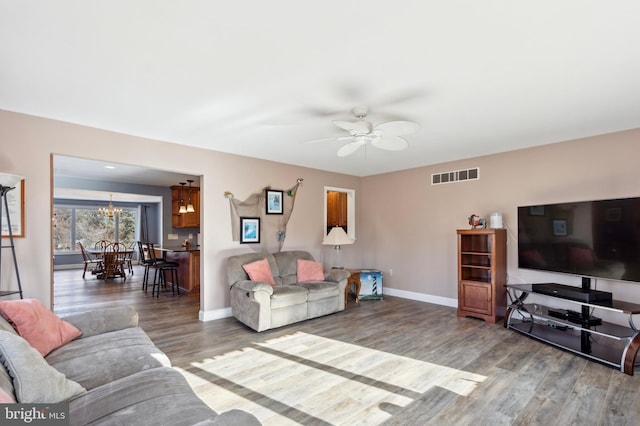 living room featuring hardwood / wood-style floors and ceiling fan with notable chandelier