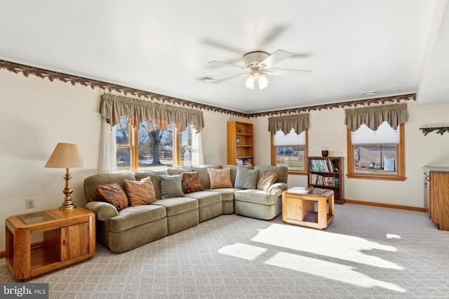 living room with ceiling fan, light colored carpet, and plenty of natural light