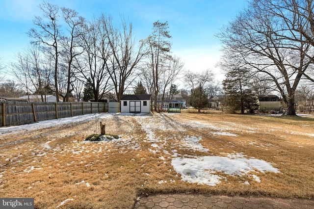 yard covered in snow featuring a storage shed