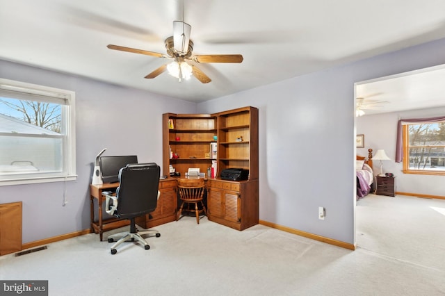 carpeted home office featuring ceiling fan