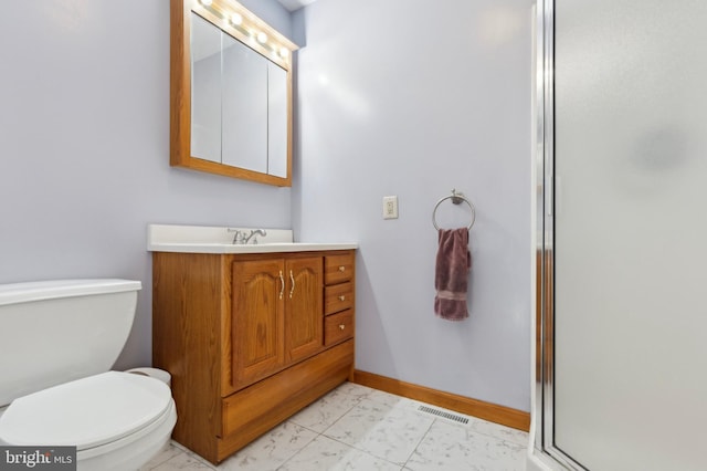 bathroom with vanity, toilet, and a shower with shower door