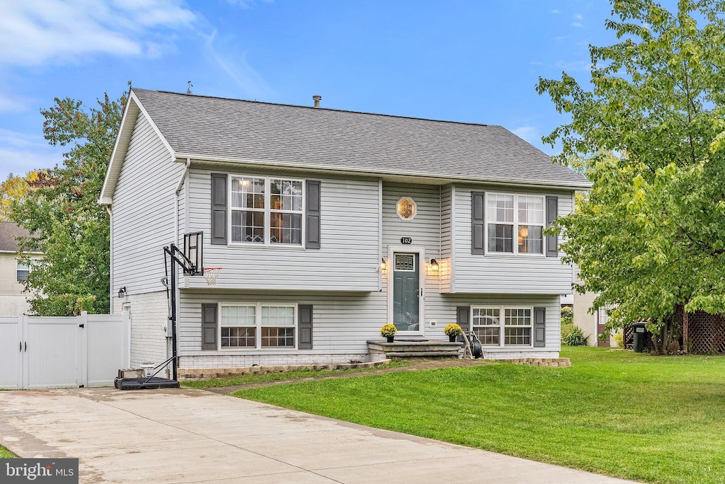 raised ranch featuring a front lawn