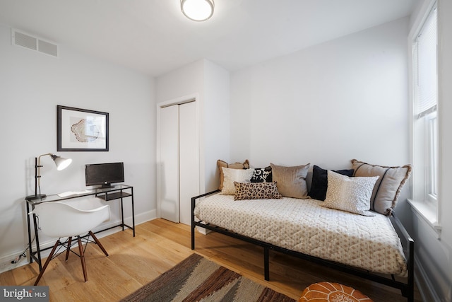 bedroom with wood-type flooring and a closet