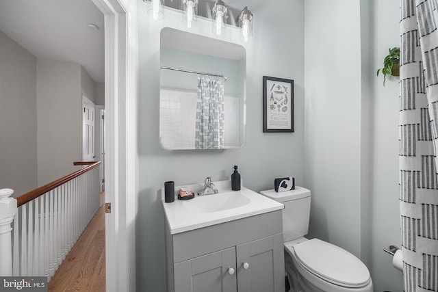 bathroom with hardwood / wood-style flooring, vanity, and toilet