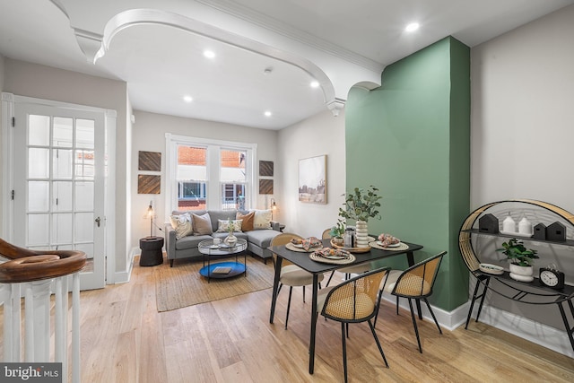 dining space featuring decorative columns and light hardwood / wood-style flooring