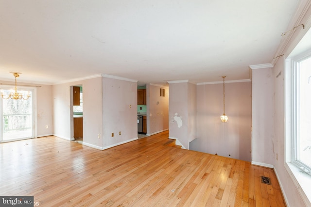 unfurnished living room with crown molding, hardwood / wood-style floors, and a notable chandelier