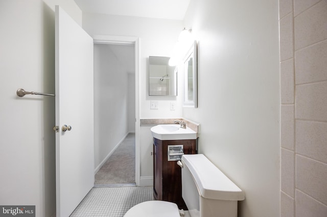 bathroom featuring toilet, baseboards, and vanity