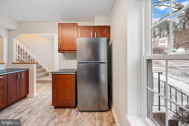 kitchen featuring brown cabinetry and freestanding refrigerator