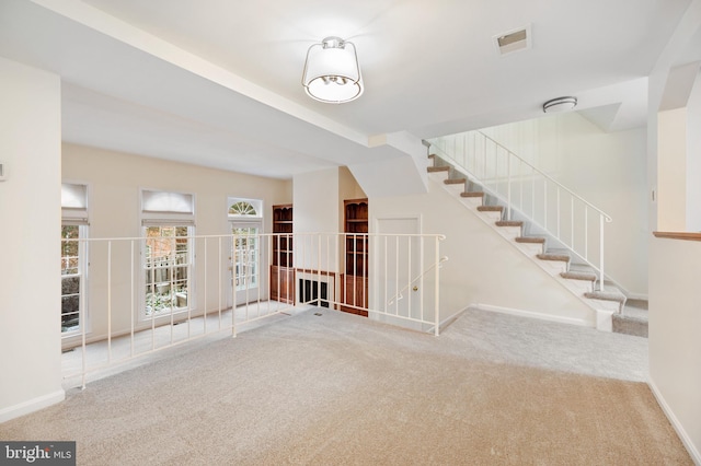 spare room with carpet floors, baseboards, and visible vents