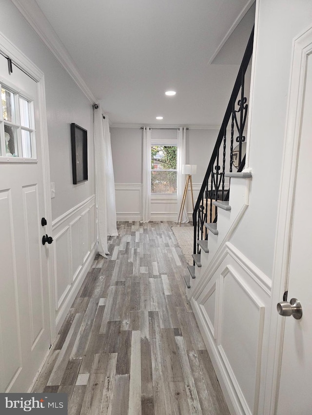 entryway featuring hardwood / wood-style floors and crown molding