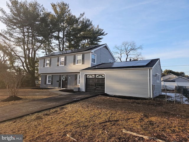 view of front of home featuring a garage and solar panels