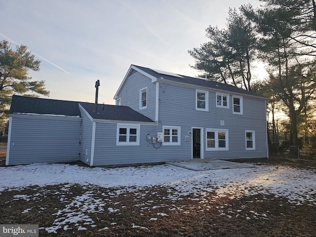 view of snow covered back of property