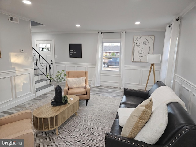 living room with wood-type flooring and ornamental molding