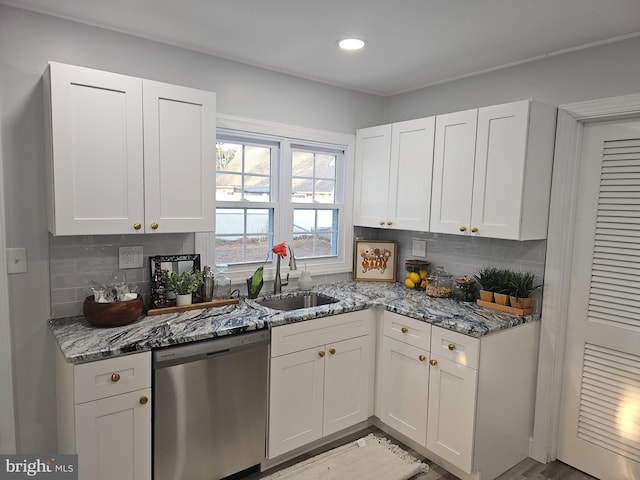 kitchen with stone counters, white cabinetry, sink, and stainless steel dishwasher