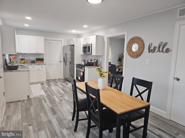 dining room featuring sink and light hardwood / wood-style floors