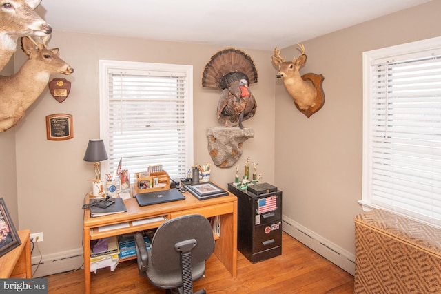 office with a baseboard heating unit, a wealth of natural light, and hardwood / wood-style floors